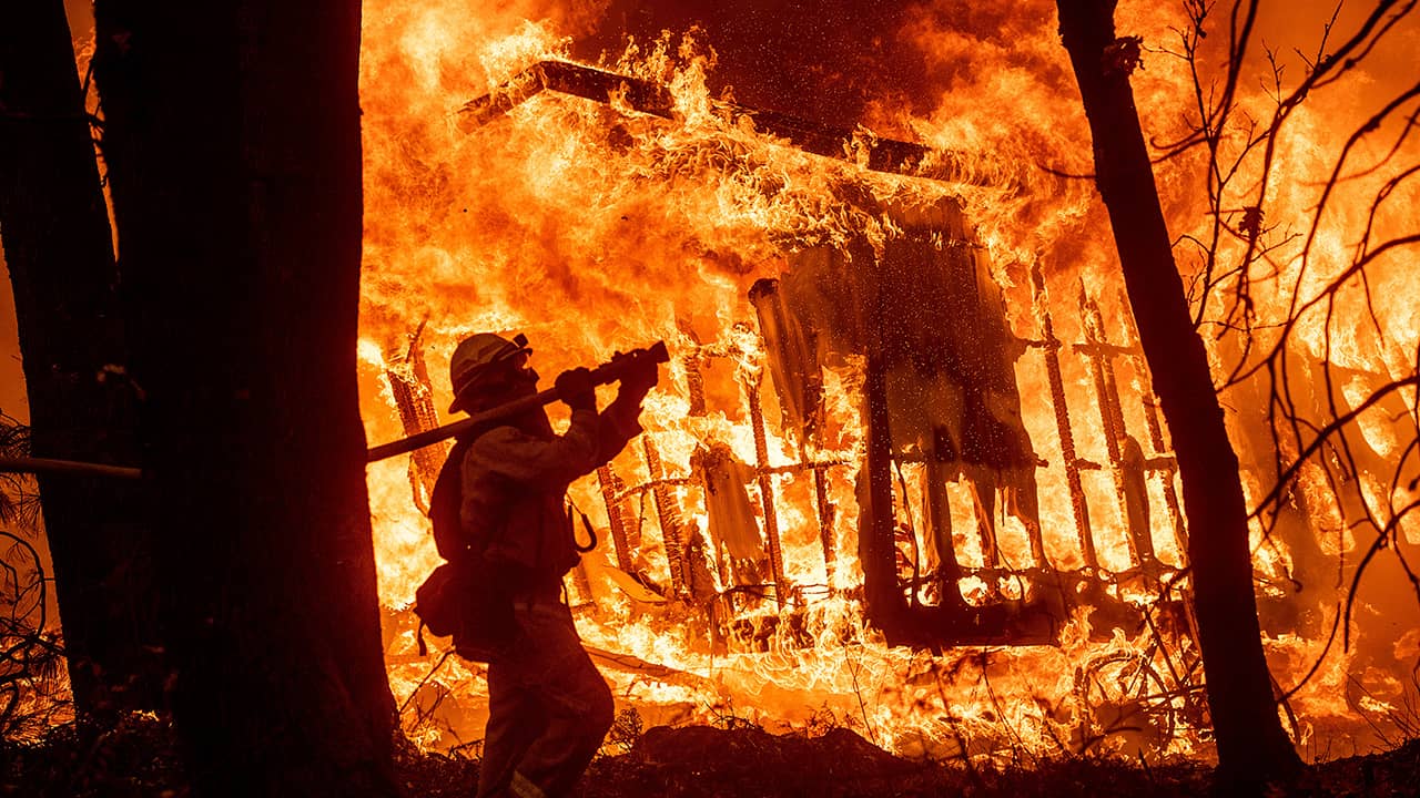 Photo of firefighter Jose Corona spraying water at flames