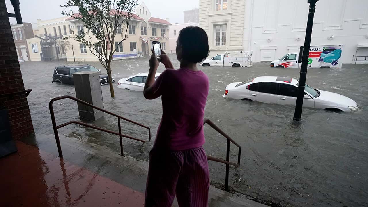 Photo of a woman taking photos of the flooding