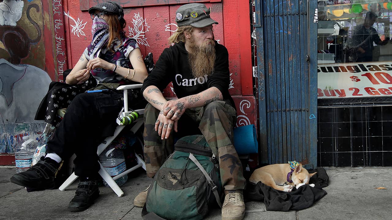 Photo of Stormy Nichole Day, Nord, and dog Hobo sitting on the street in San Francisco