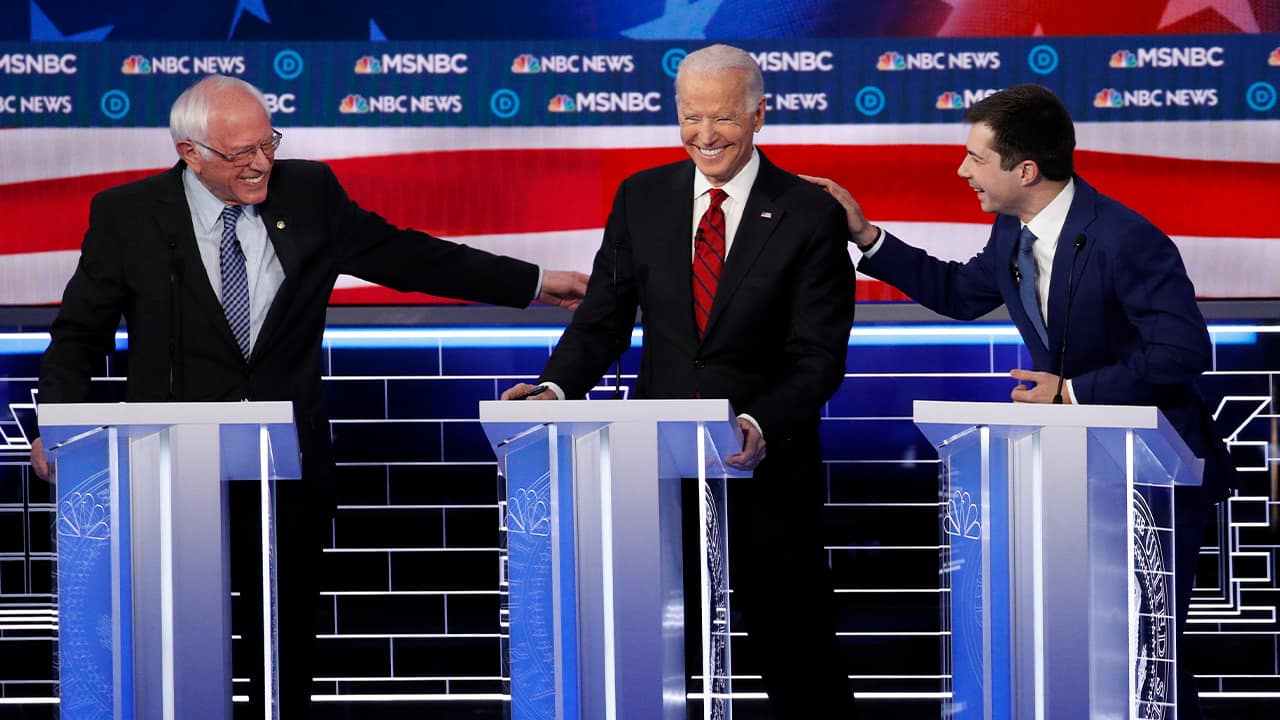 Photo of Democratic presidential candidates Sen. Bernie Sanders, I-Vt., left, and former South Bend Mayor Pete Buttigieg, right, reaching for former Vice President Joe Biden
