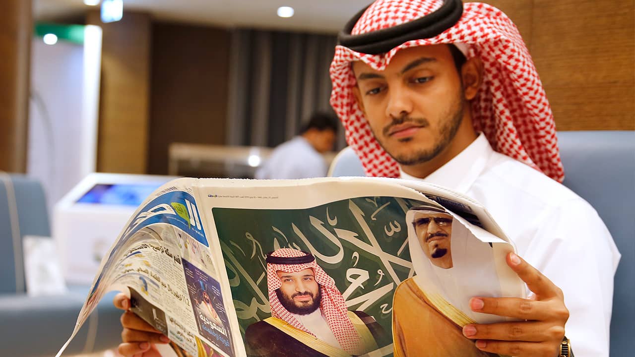 Photo of a man reading a newspaper in Mecca, Saudi Arabia