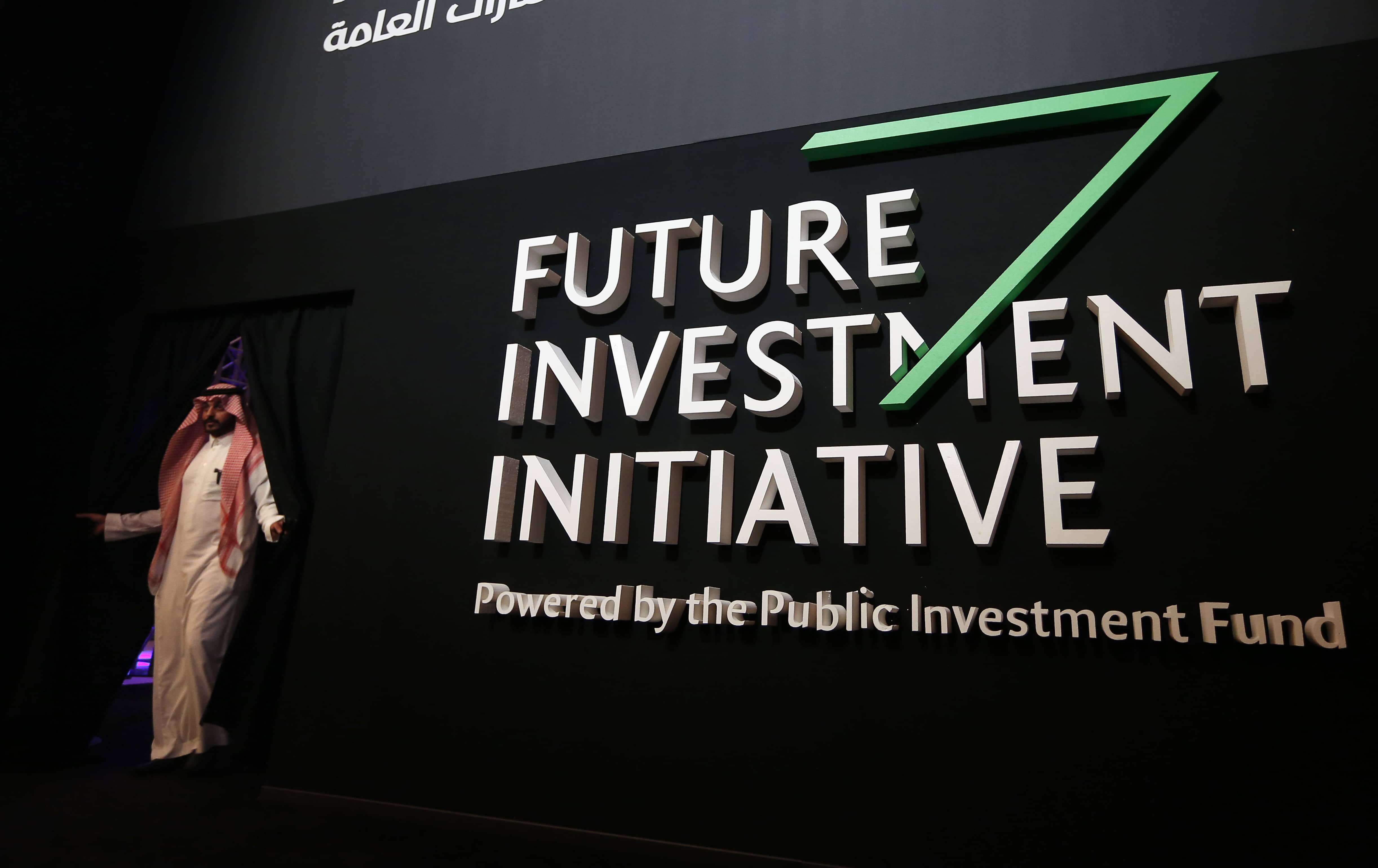 Photo of Saudi participant in front of a banner for the Future Investment Initiative conference