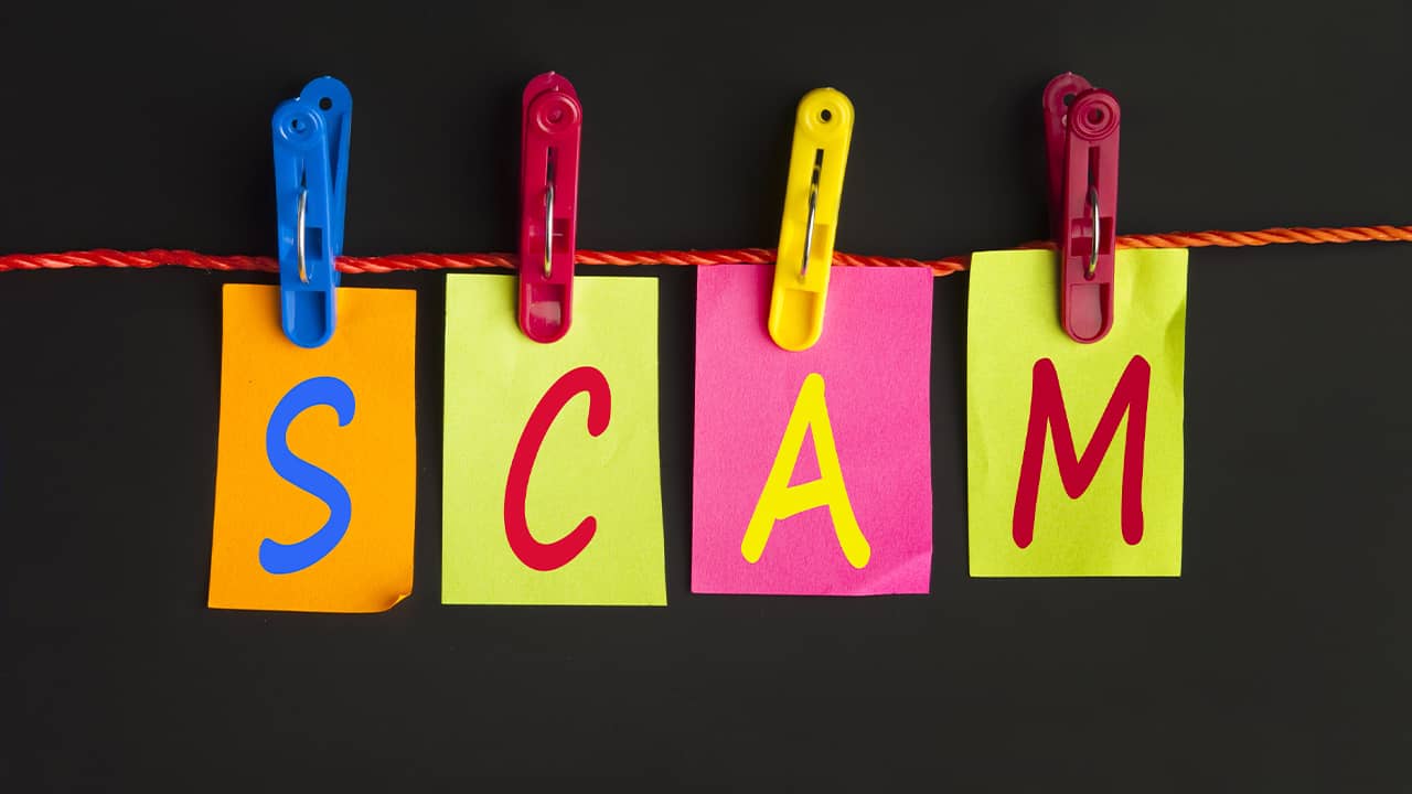 The letters s c a m hanging from a clotheslines signifying a scam