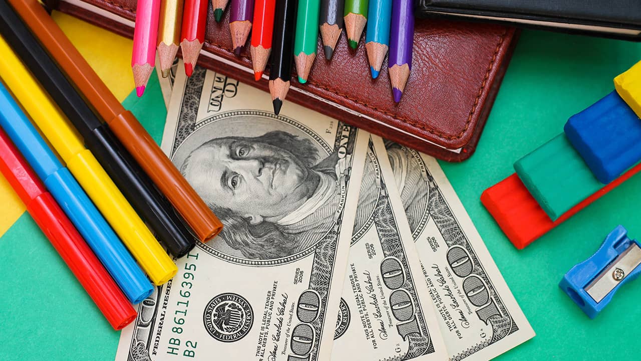 Photo of school supplies and hundred dollar bills
