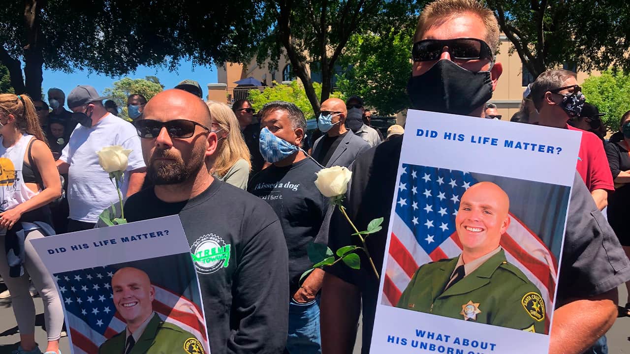 Photo of men holding posters of Sgt. Damon Gutzwiller