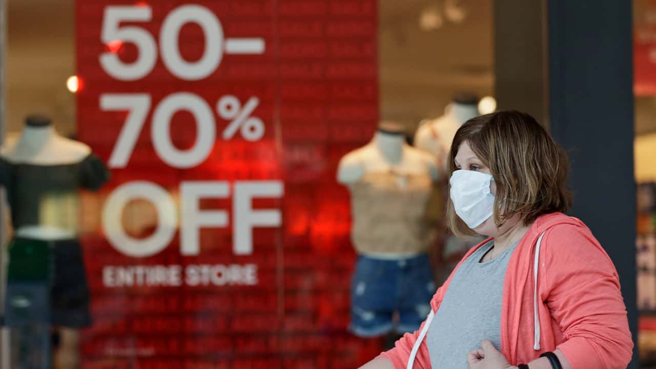 Photo of a woman walking past a store