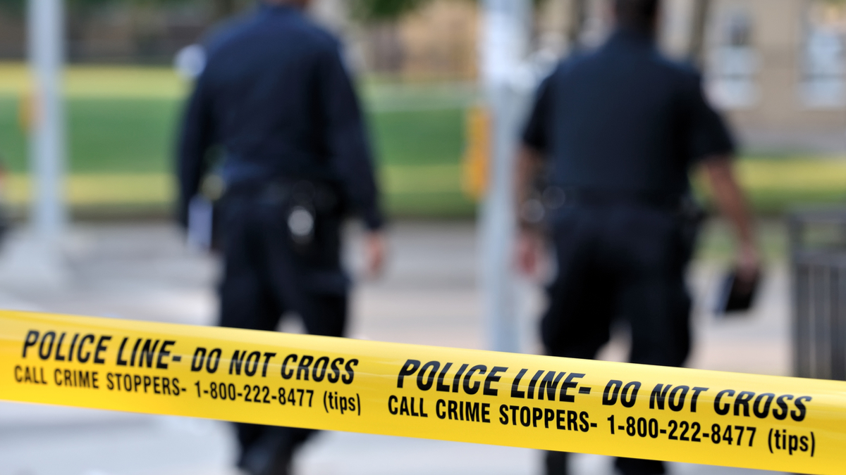 Photo of crime scene tape and two police officers