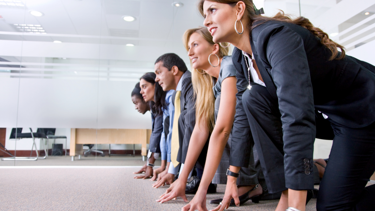 Photo of young men and women in business attire at the starting line.