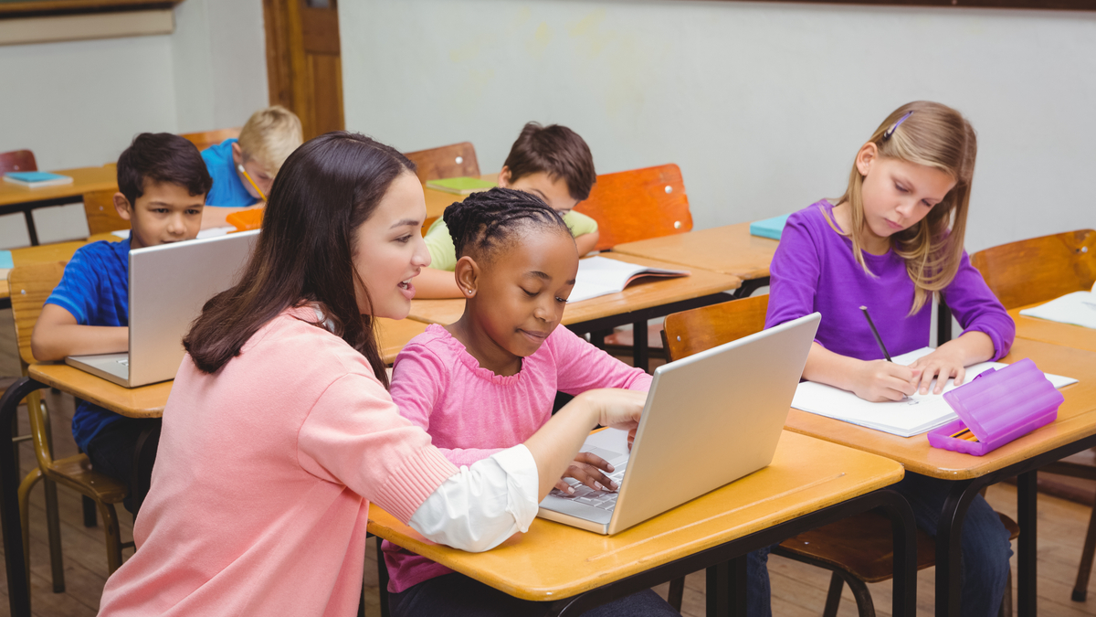 Shutterstock photo of teacher with young math students at their desks