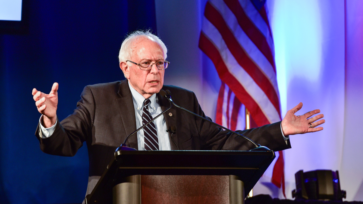 Picture of Sen. Bernie Sanders speaking with American flag in the background