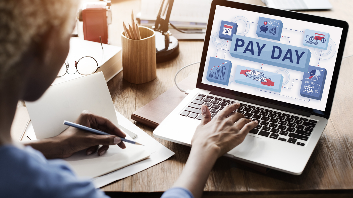 Photo of man paying bills via computer on payday