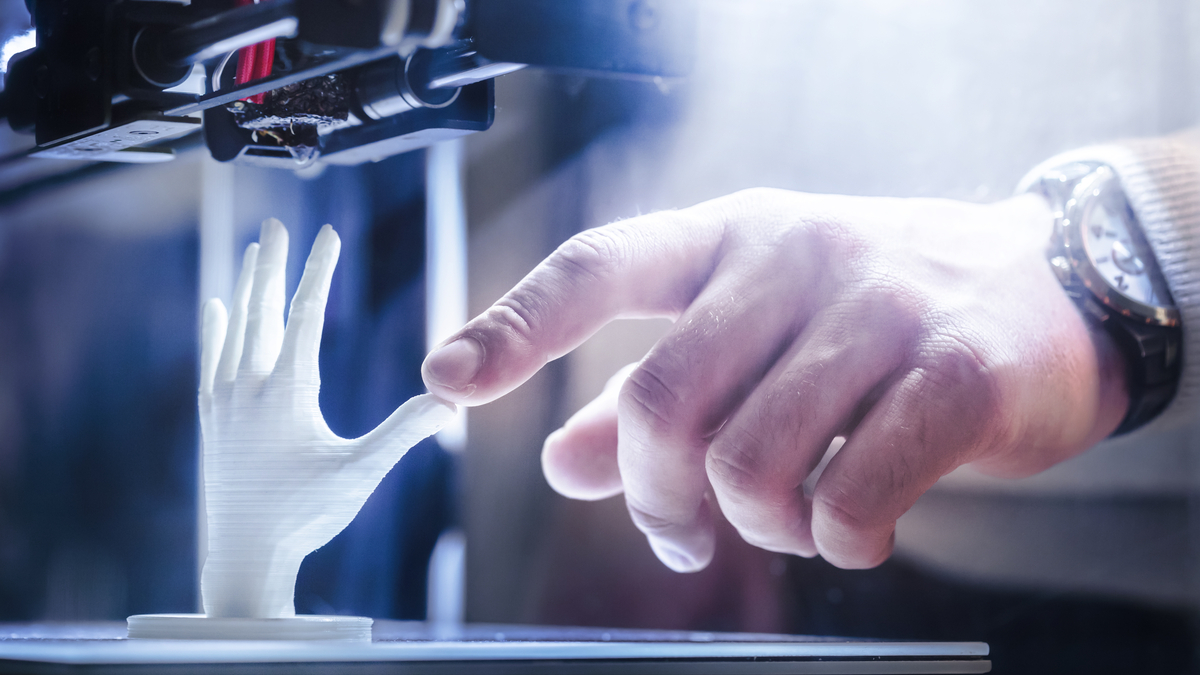 Photo of a 3D printer creating a plastic hand