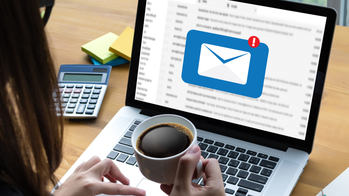 Photo of woman looking at email pop up on her laptop