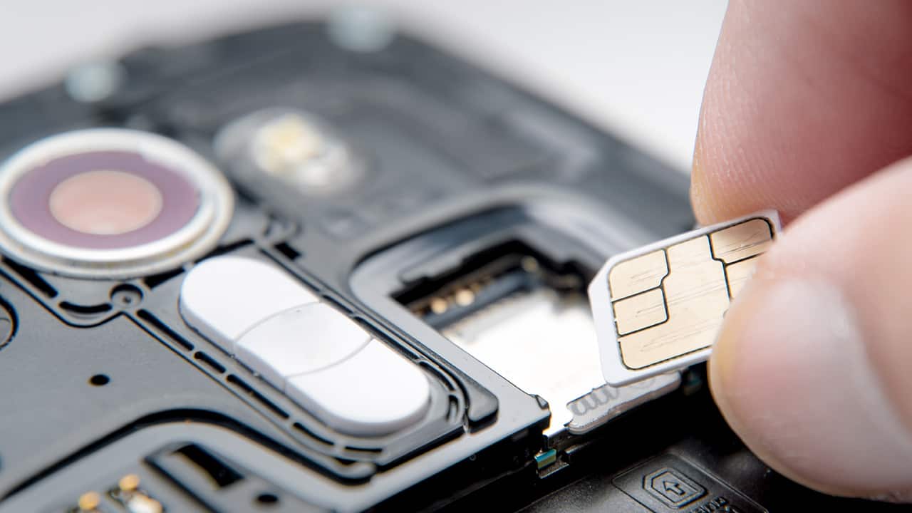 Photo of a SIM card and a cell phone