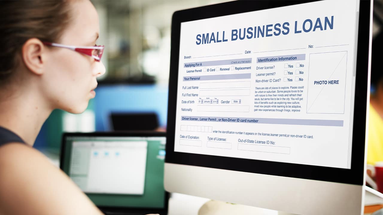 Photo of a woman looking at a small business loan form on a computer