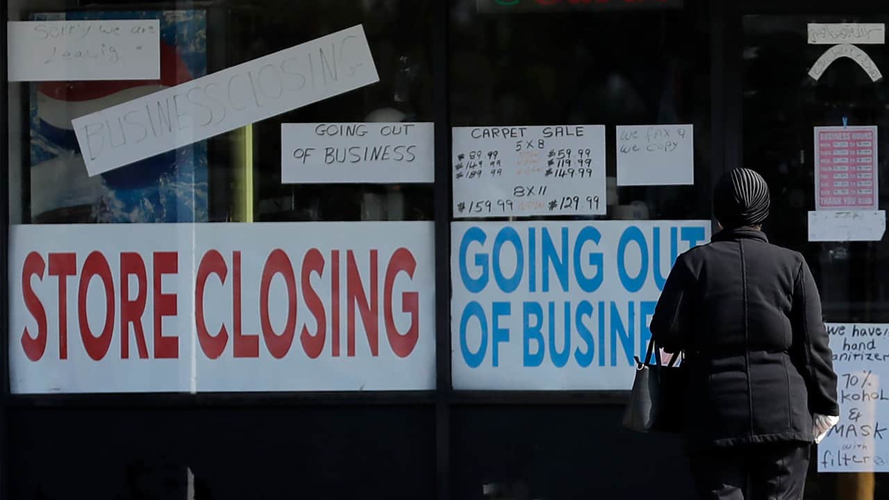 Photo of a store with closing signs on the front 