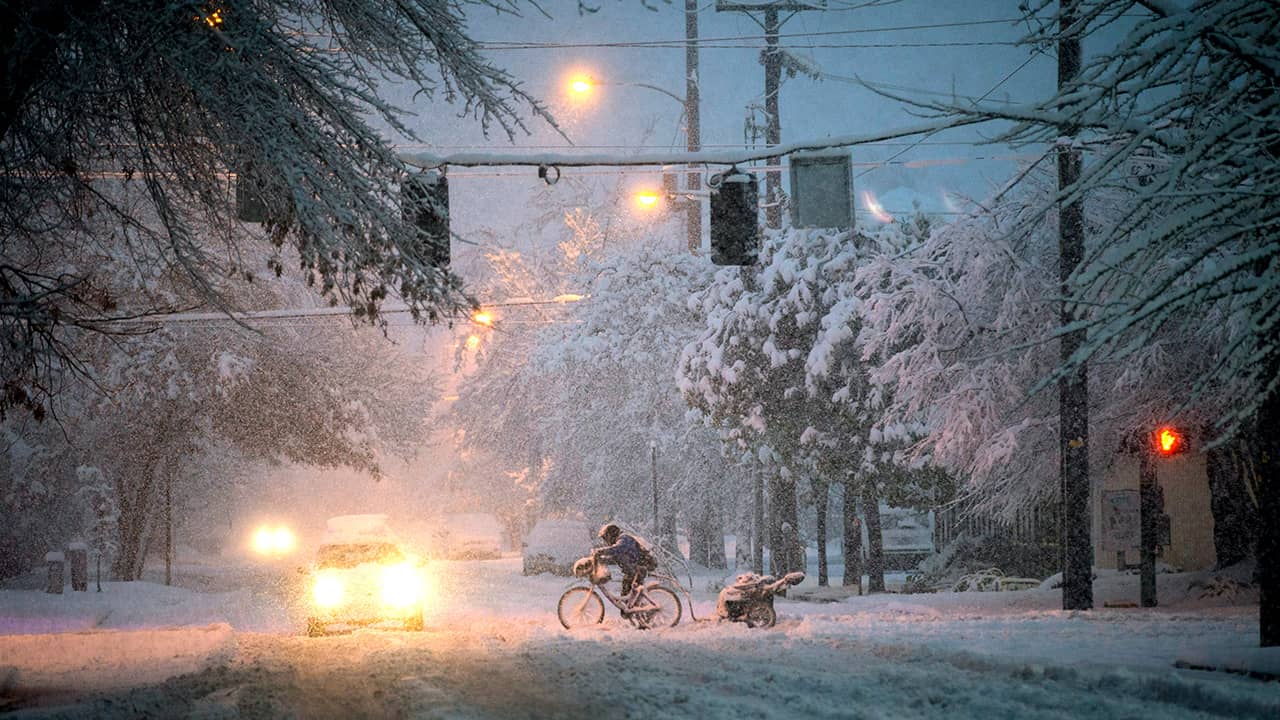 Photo of man riding a bicycle through the snow in Oregon
