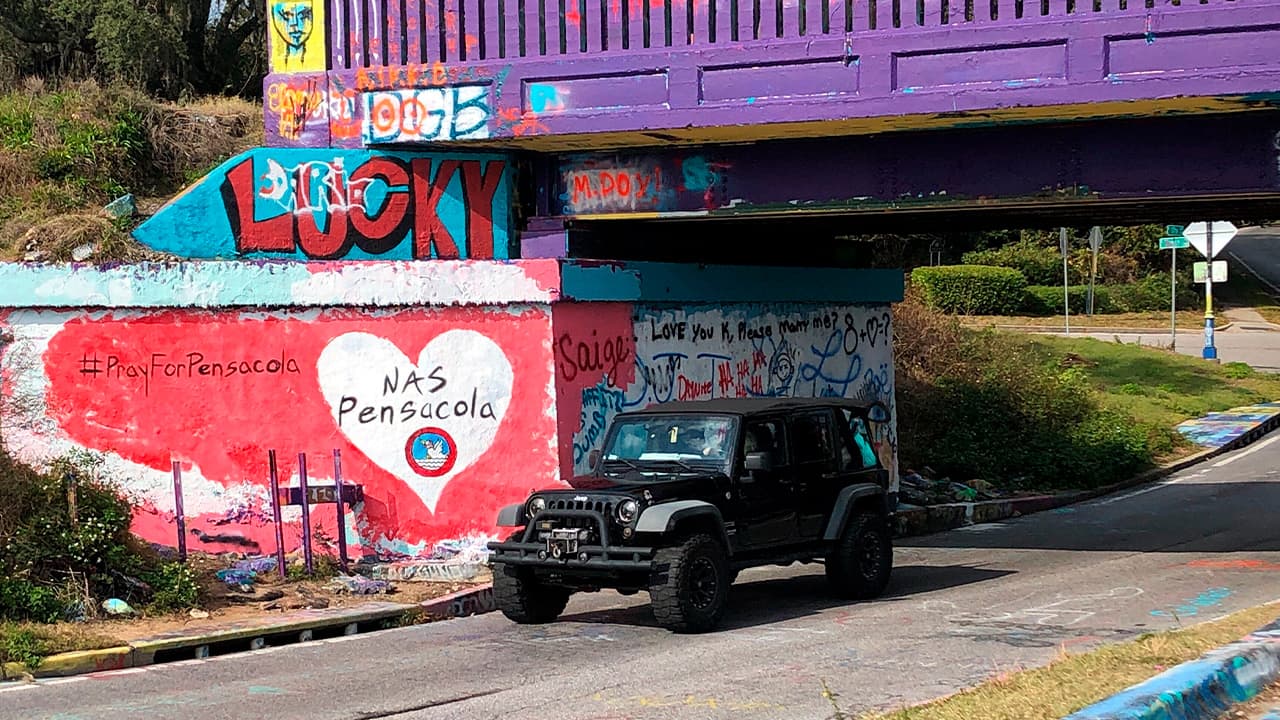 Photo of a vehicle driving by a tribute to the victims of the Naval Air Station Pensacola