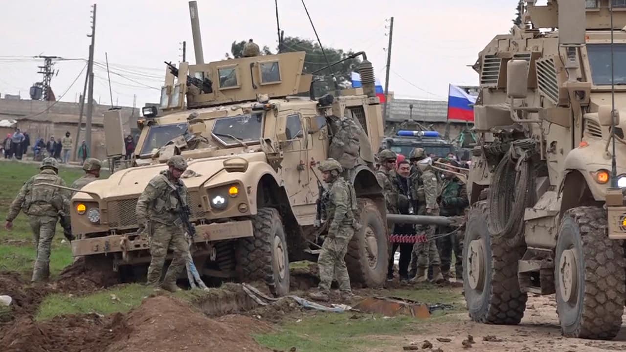 Photo of soldiers gathering next to an American military convoy