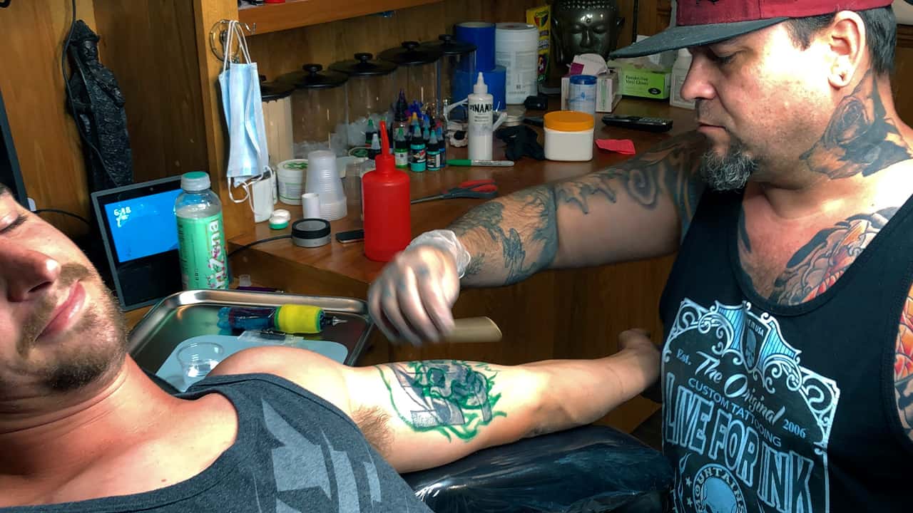 Photo of a man getting a tattoo covered up