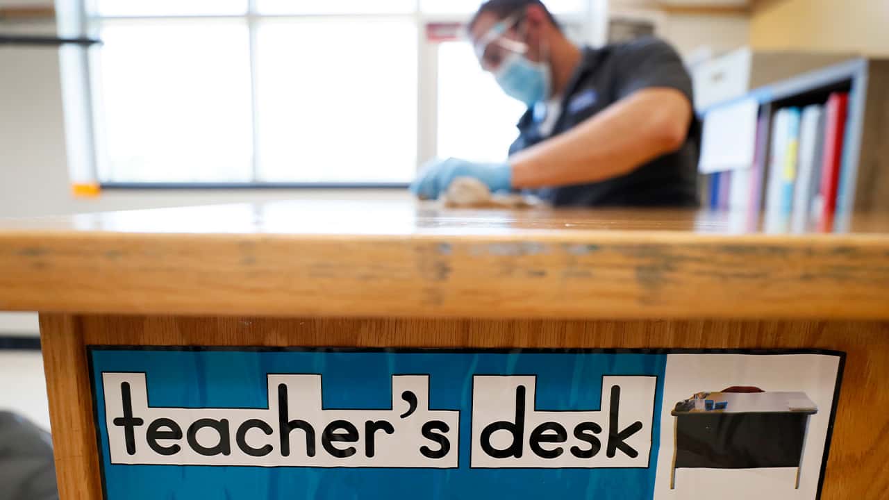 Image of a teacher's desk being sanitized in preparation for the reopening of schools during the coronavirus pandemic