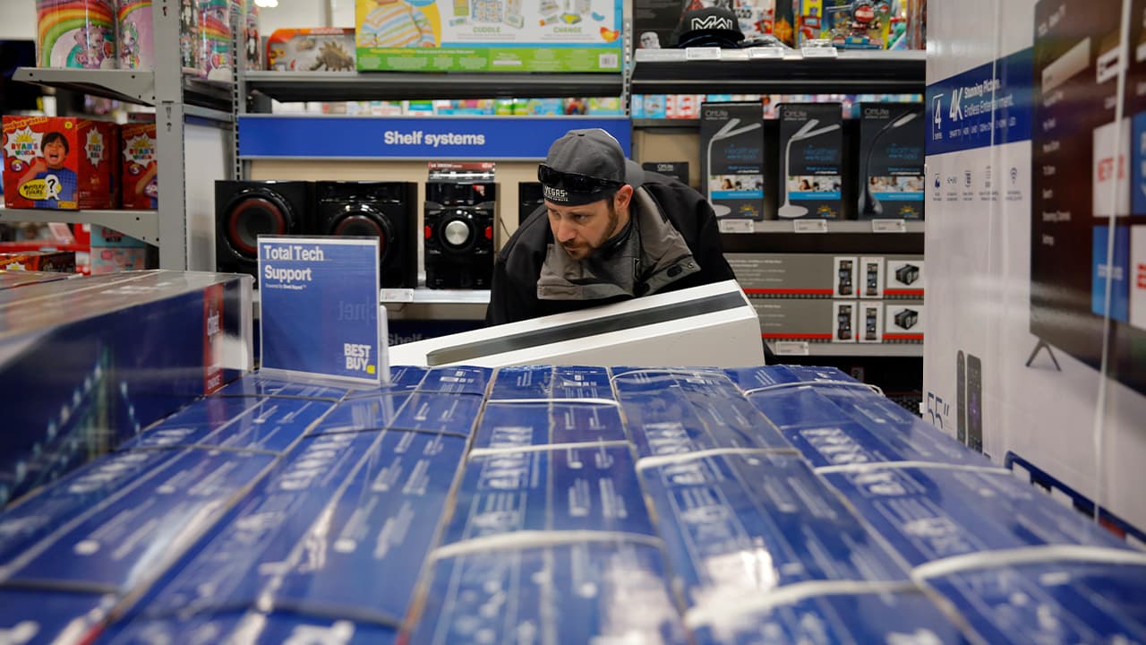 Photo of a man looking a TVs 