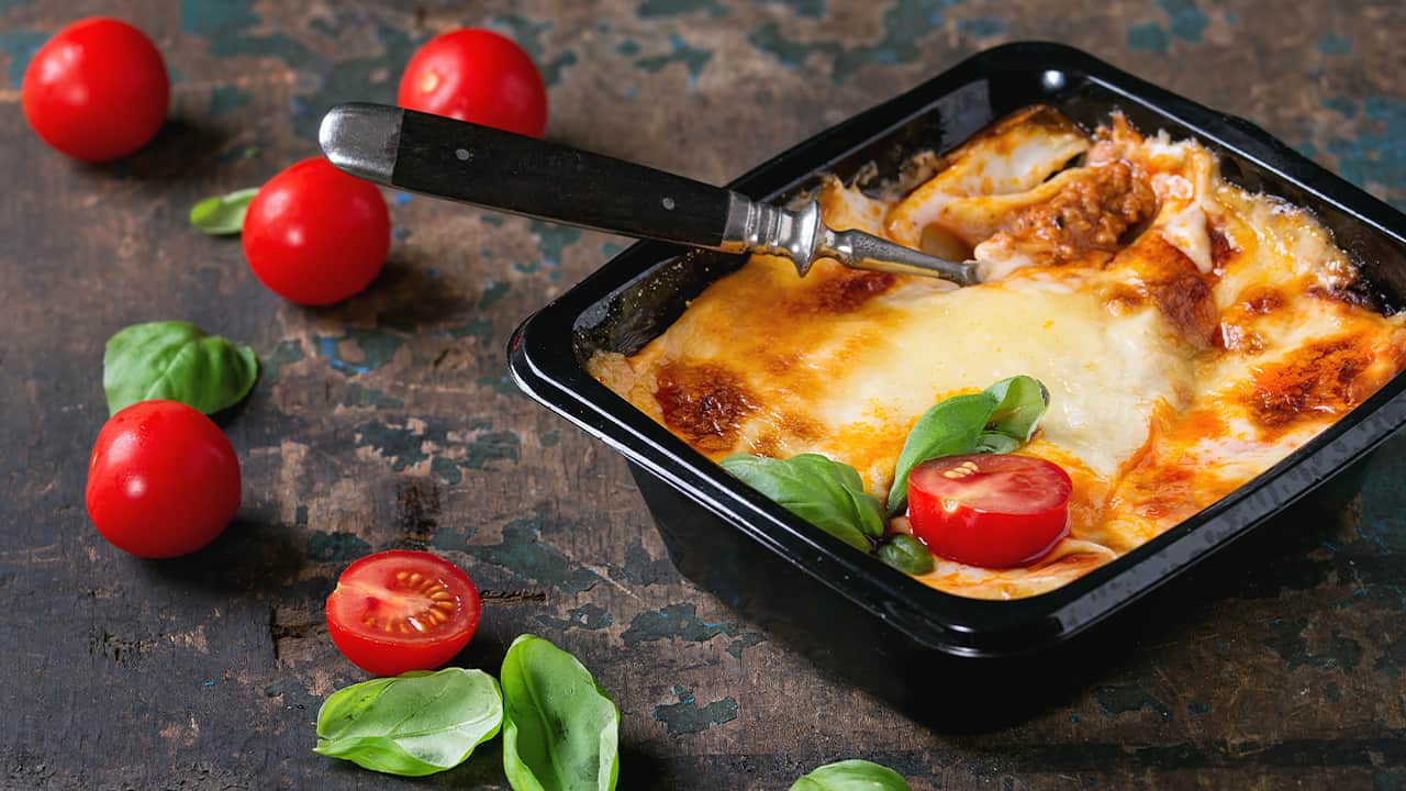 Photo of baked lasagna in a to-go container