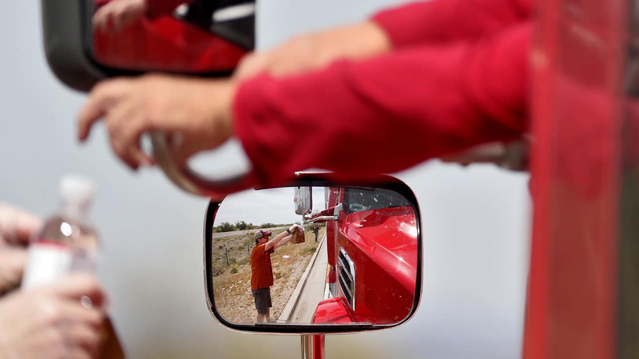 Photo of a mand giving lunch to a truck driver in Arizona 