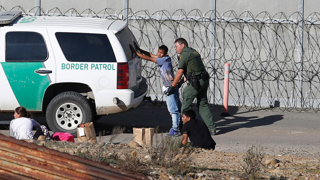 Photo of asylum seeker being taken into custody by US Border Patrol