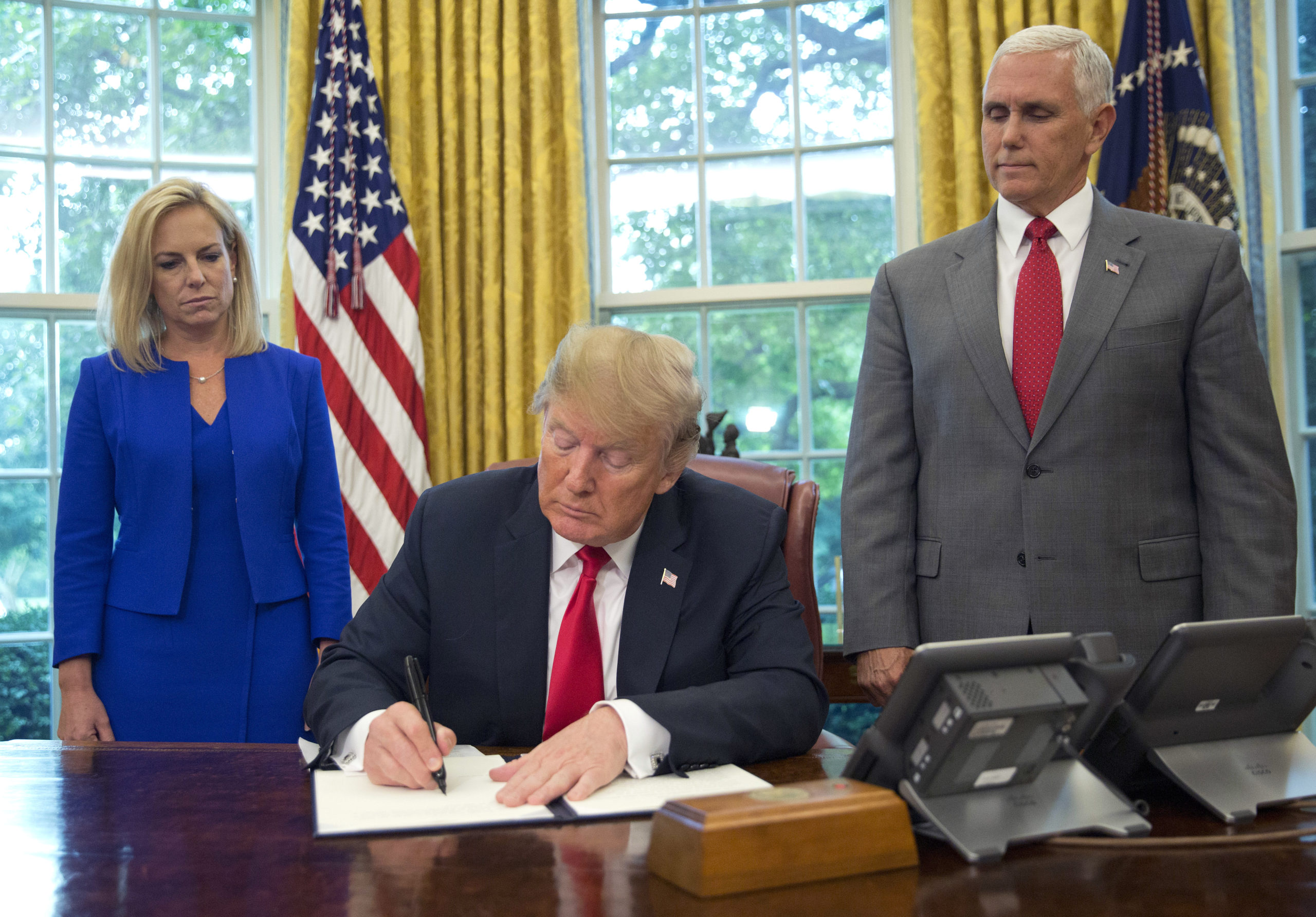 Photo of President Donald Trump signing order ending the separation of detained immigrant parents and children