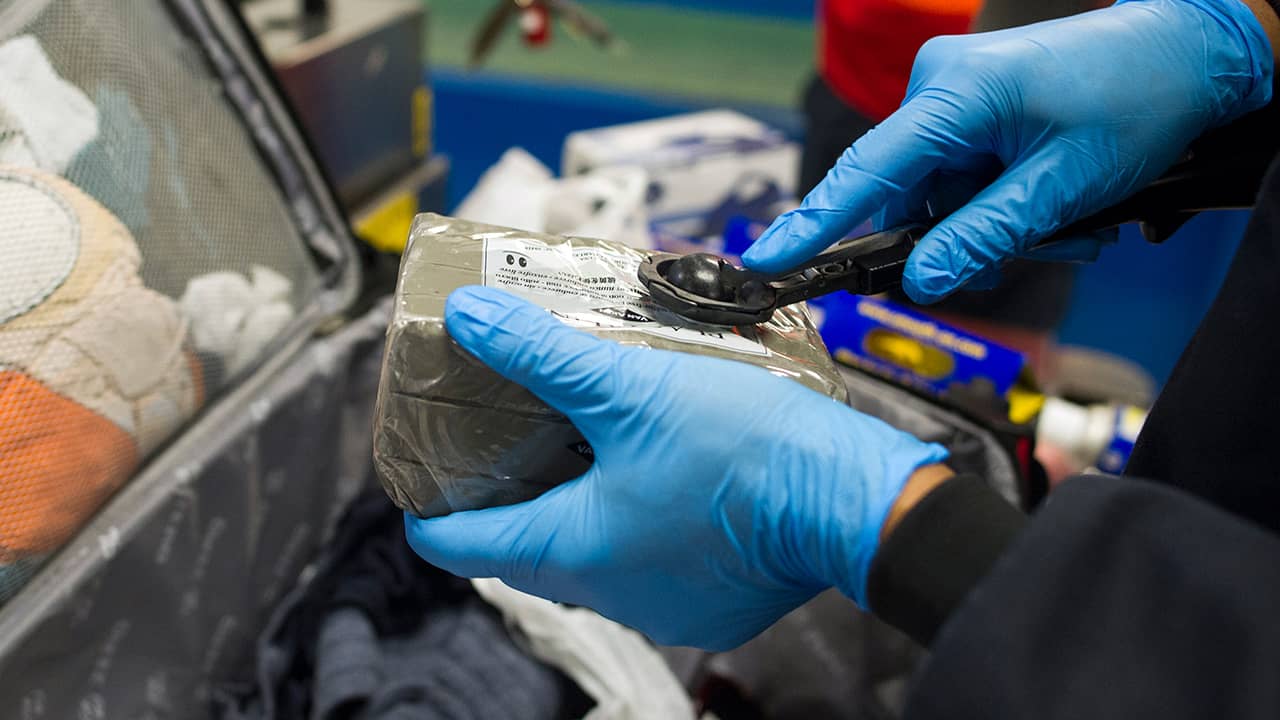 Photo of Transportation Security Adminstration (TSA) transport security officer Jon McKoy wiping an item