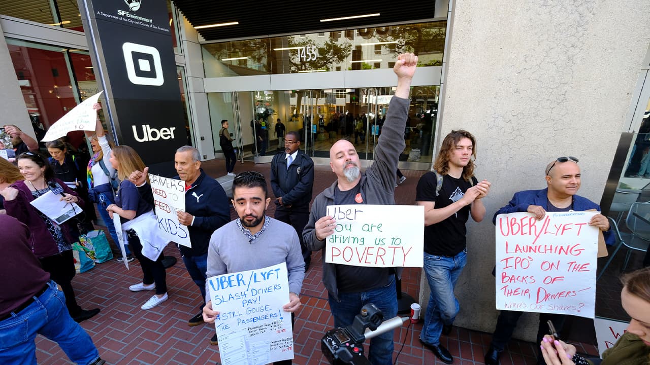 Photo of Uber and Lyft drivers carryh signs during a demonstration 