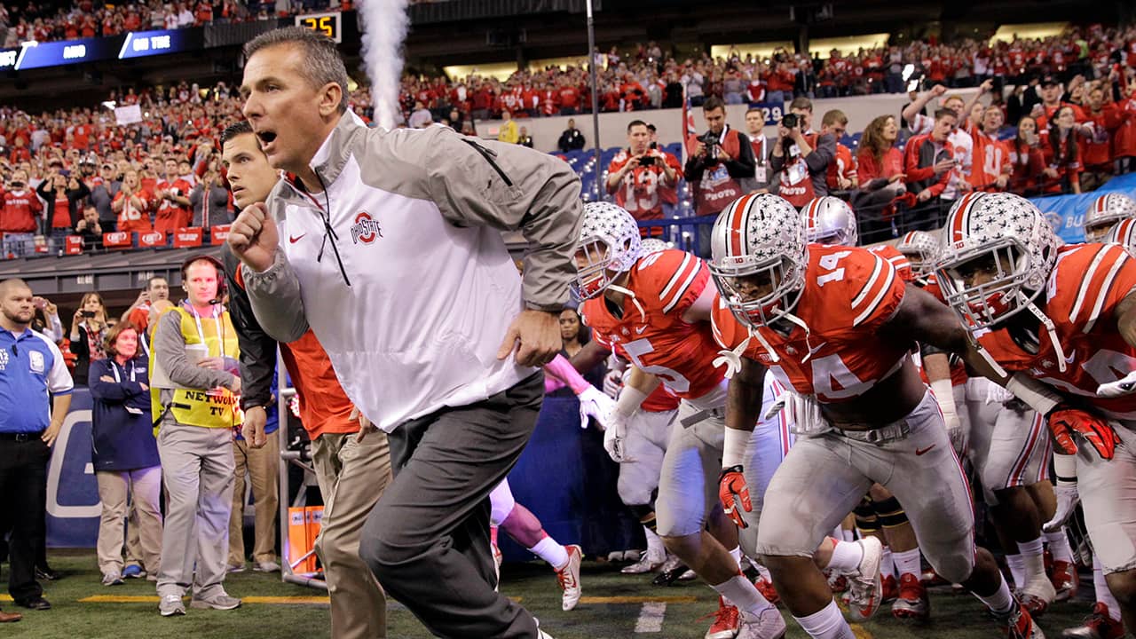 Photo of Urban Meyer running onto the field with his team