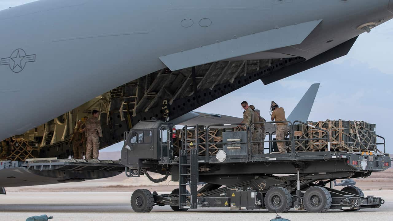 Photo of U.S. service members loading military equipment
