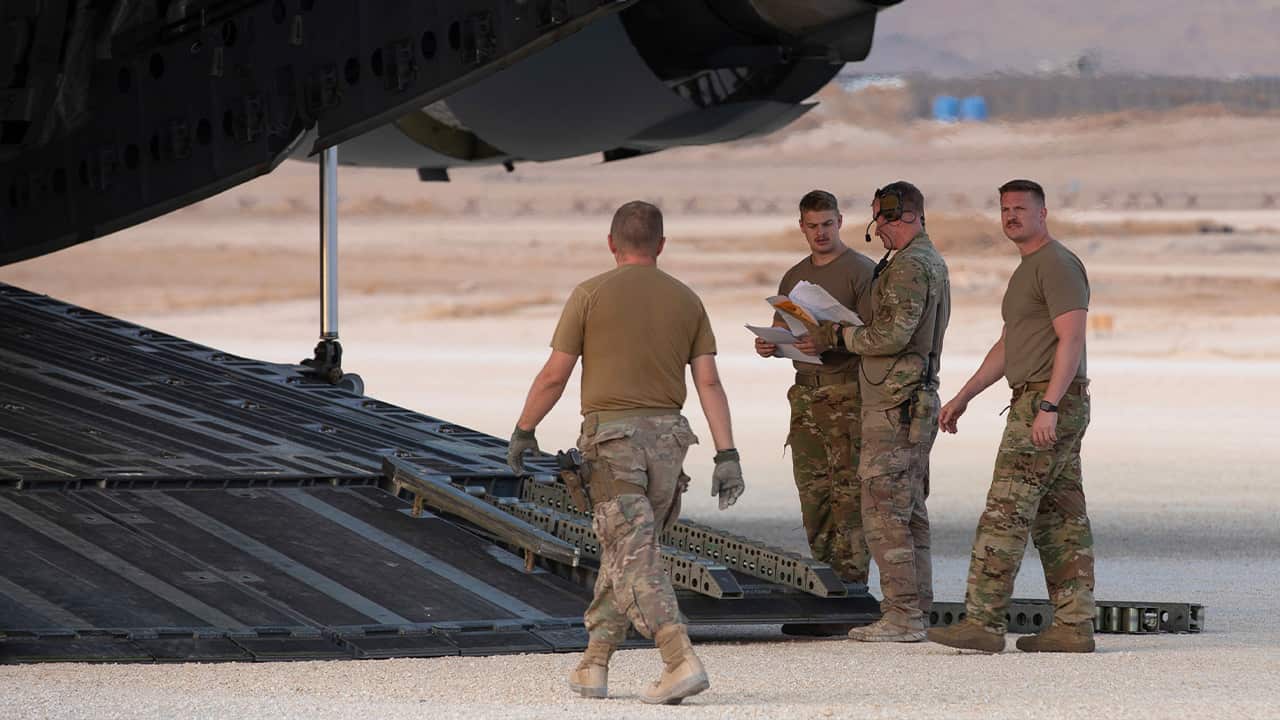 Photo of U.S. Airmen checking their manifest 