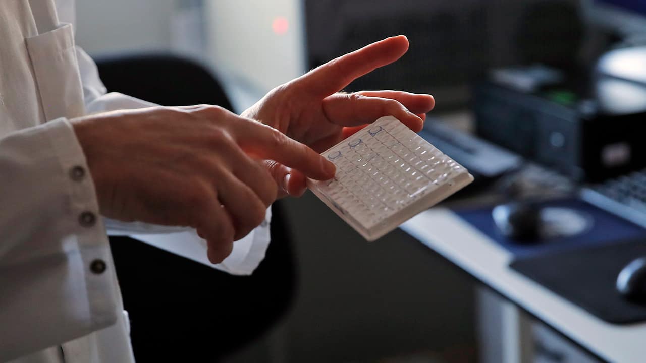 Photo of a scientist holding samples 
