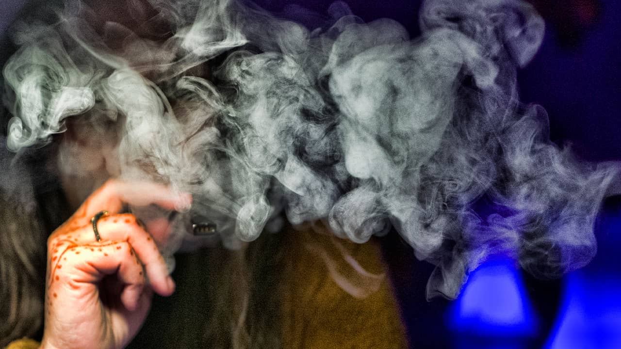 Photo of a person hidden behind vape smoke