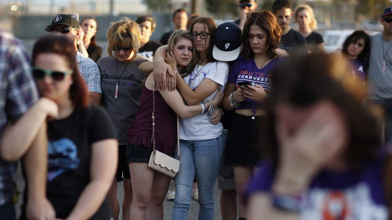 Photo of people comforting each other during a vigil in 2018 