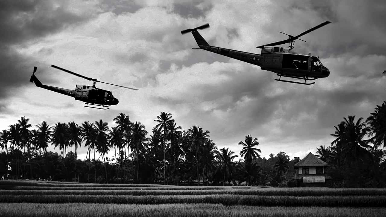 Photo of Vietnam War 'style' B&W image circa 1968 of two helicopters flying low over the rice paddies of South Vietnam looking for Viet Cong insurgents during the Tet Offensive in 1968.