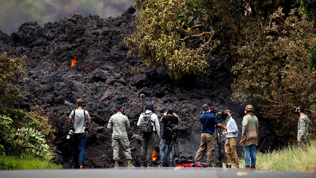 Photo of members of the media recording the wall of lava in Pahoa, HI