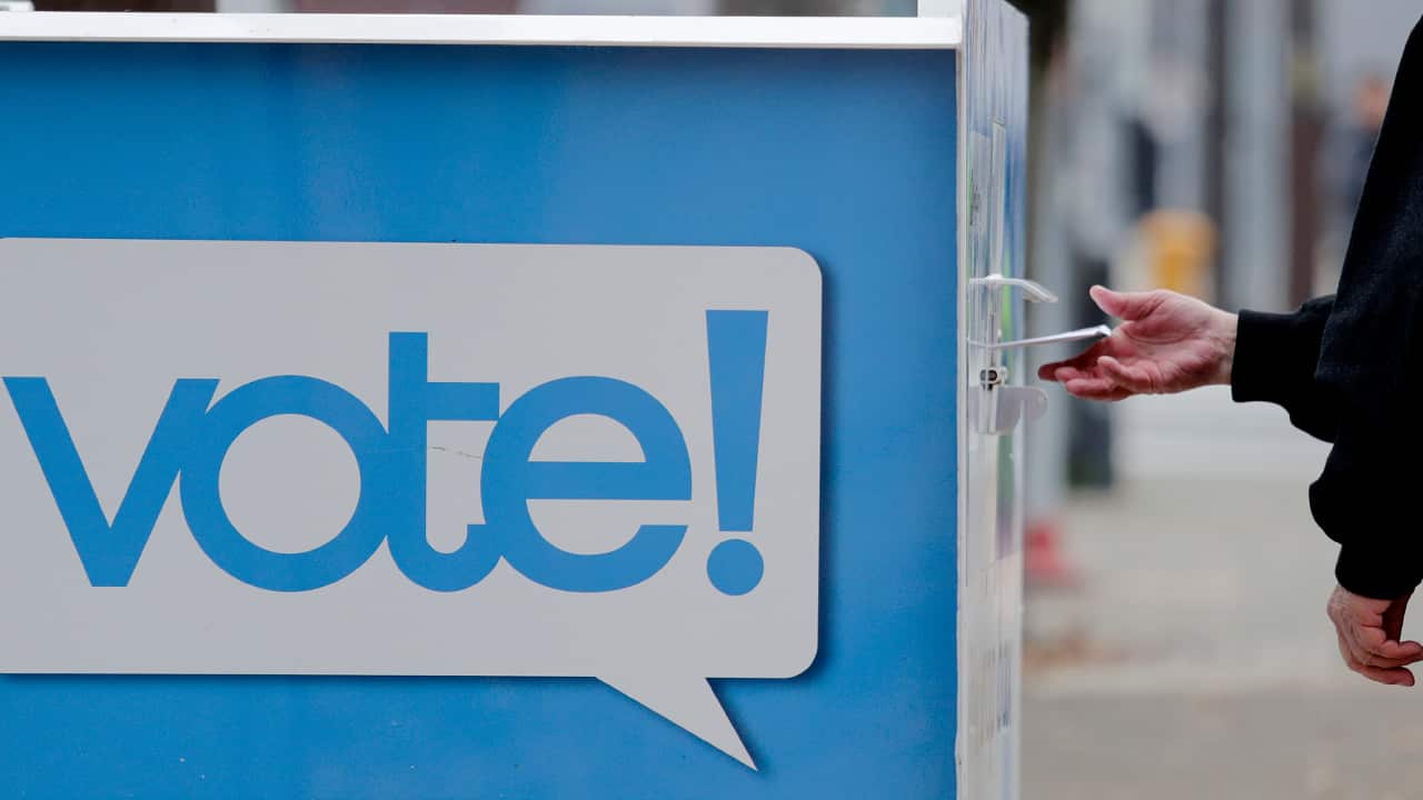 Photo of a voter and a ballot box in Seattle