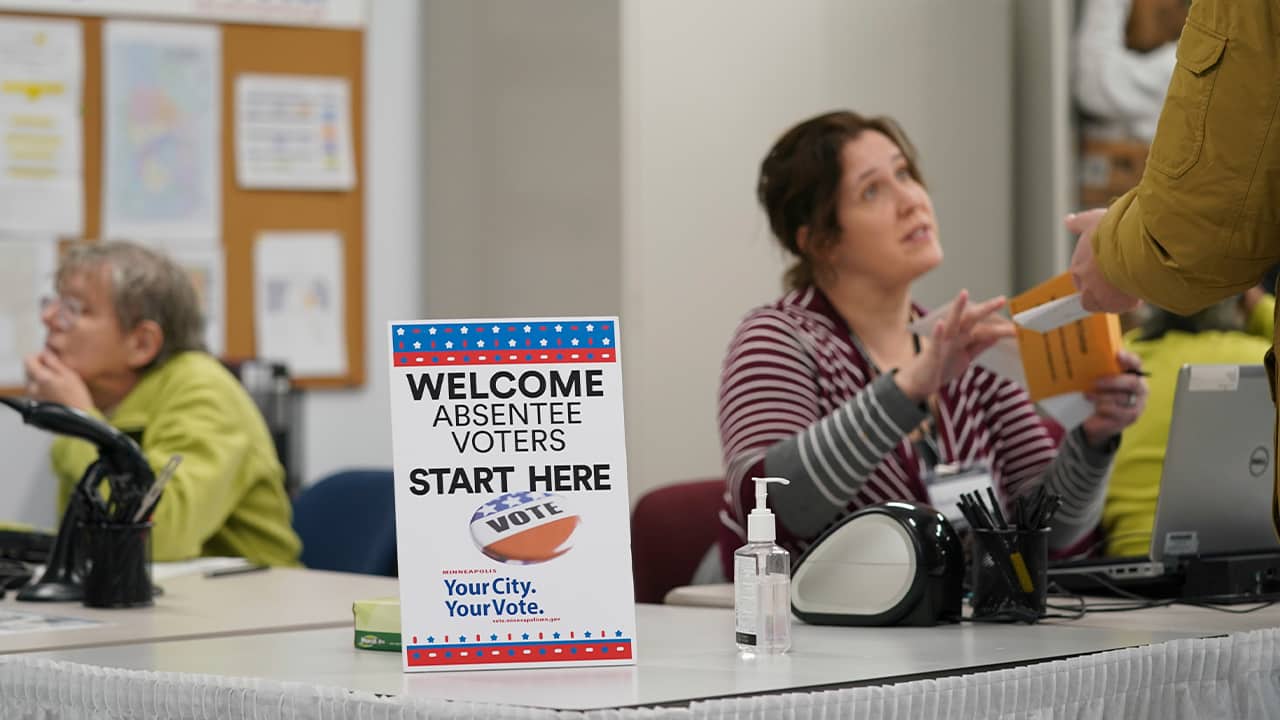 Photo of a poll worker speaking to a voter