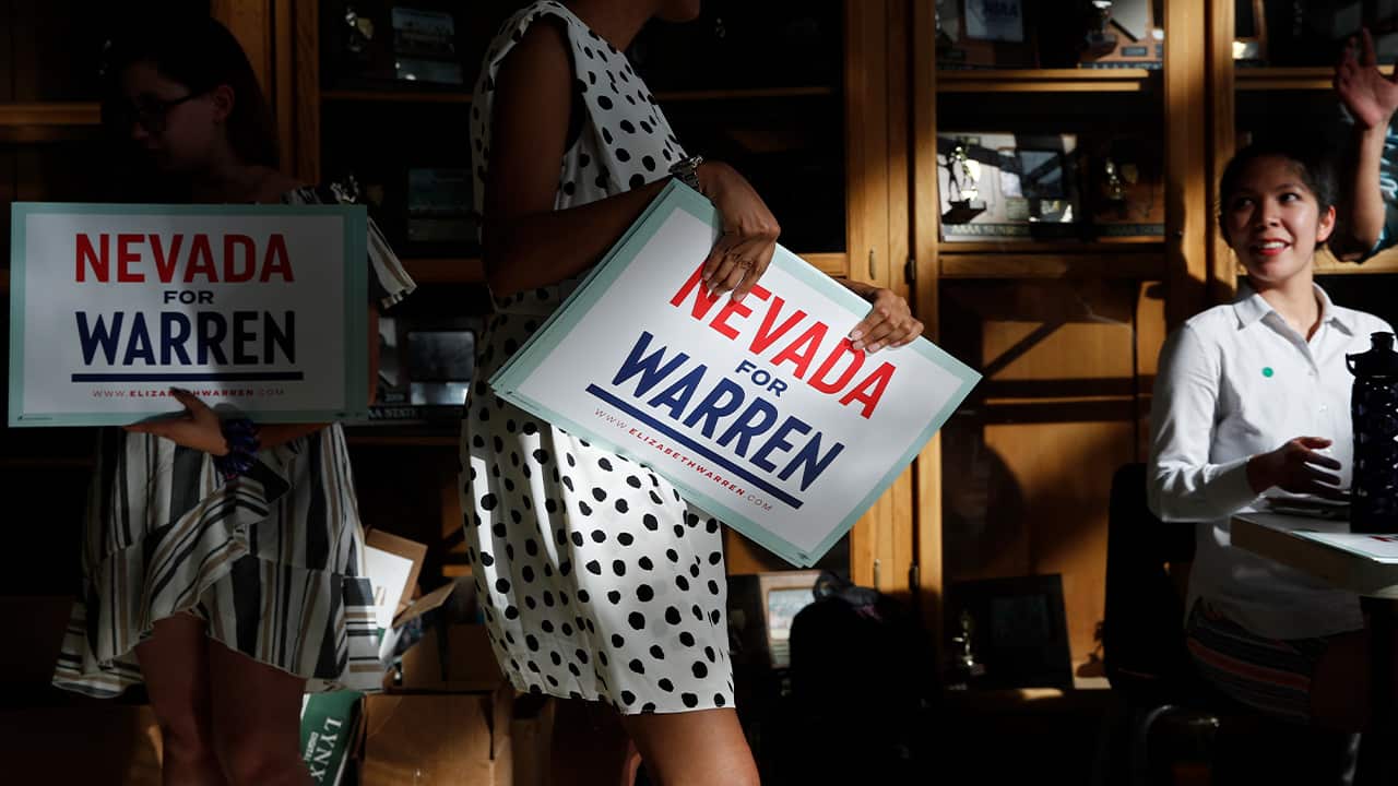 Photo of people handing out signs before a rally