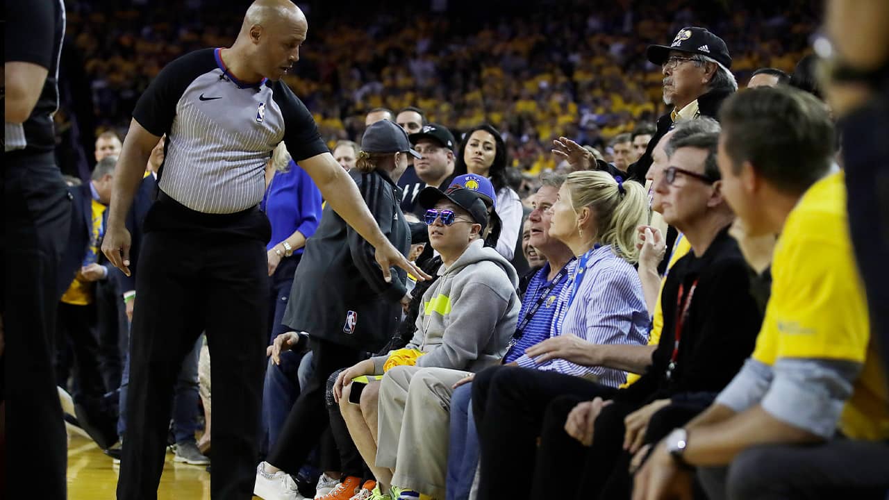 Photo of referee Marc Davis gestures toward Warrior investor Mark Stevens