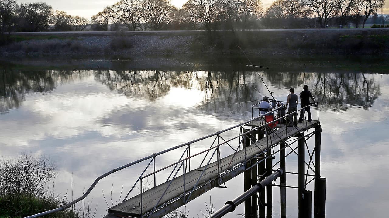 Photo of people trying to catch fish along the Sacramento River in the San Joaquin-Sacramento River Delta, near Courtland, Calif.