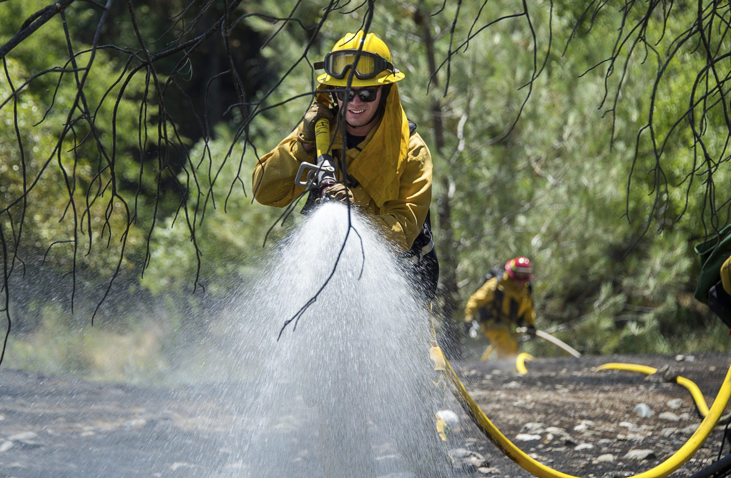 AP photo of fire crews watering down vegetation on Cache Creek Road