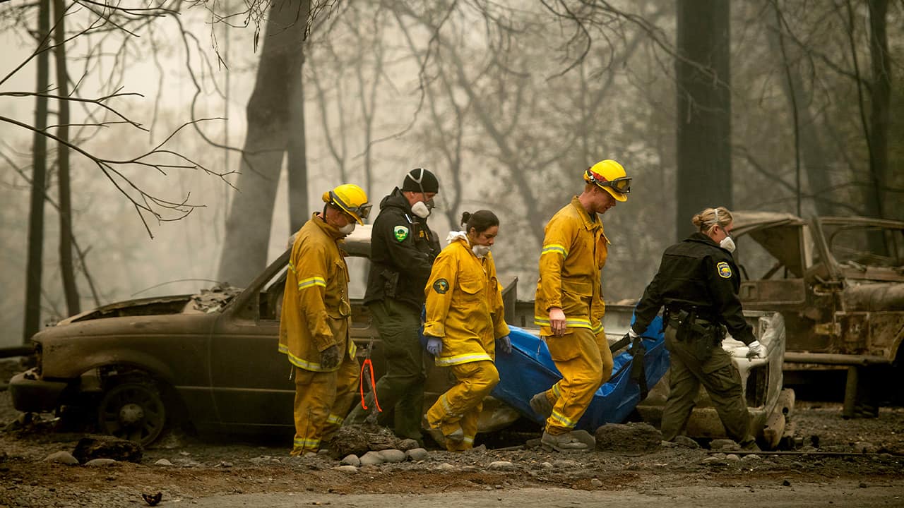 Photo of firefighters and deputies carrying a body of a Camp Fire victim