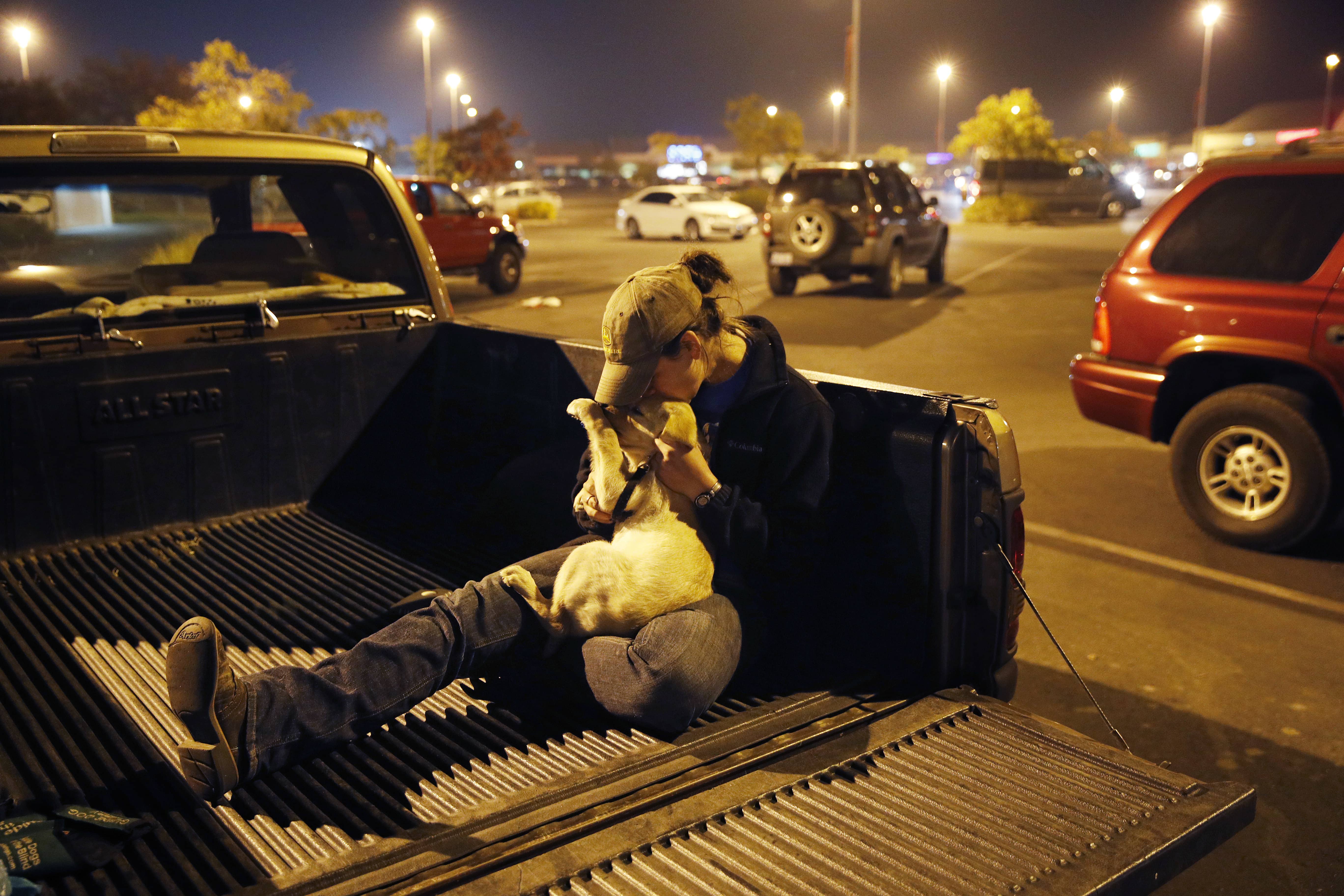 Photo of a California wildfire victim kissing her dog in the bed of her truck