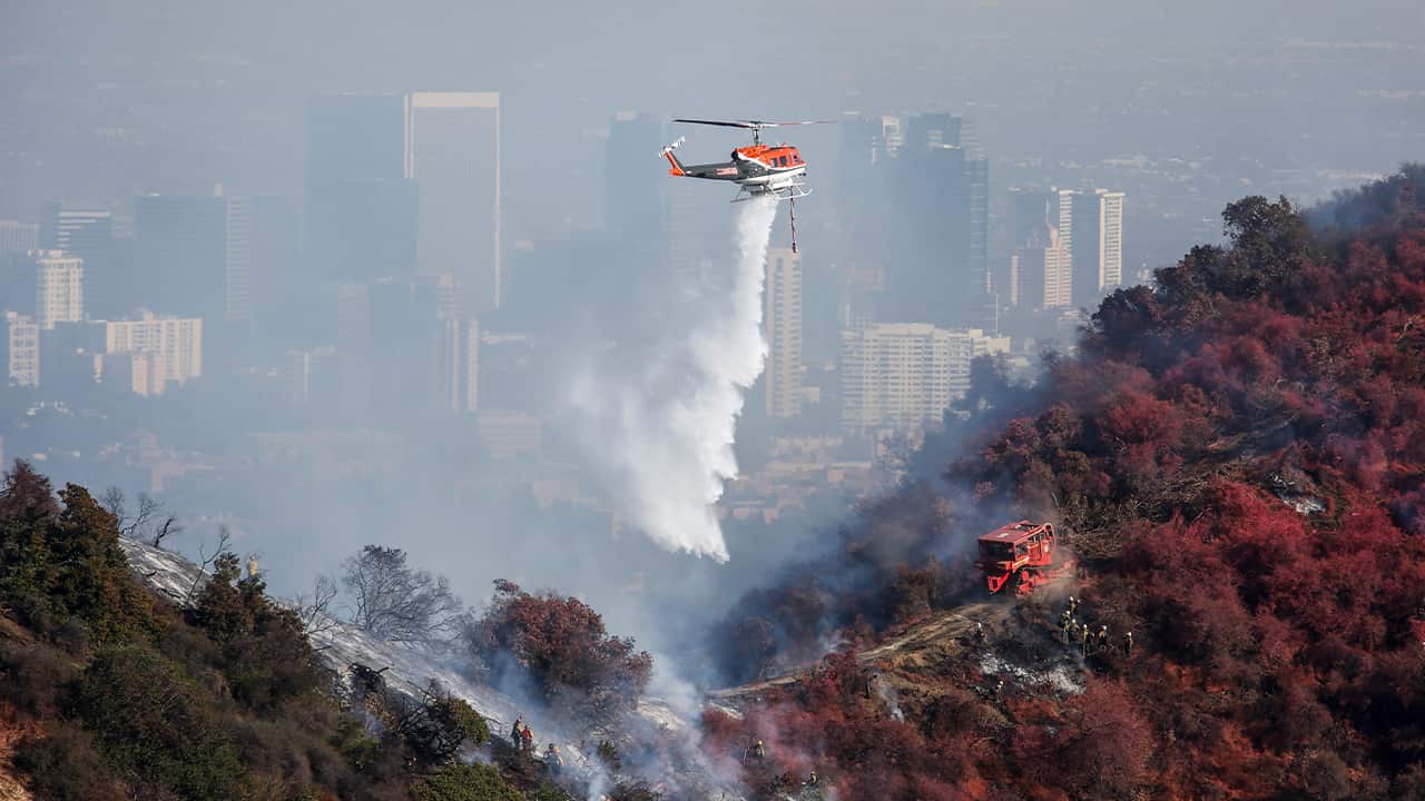 Photo of a helicopter dropping water on the Getty Fire