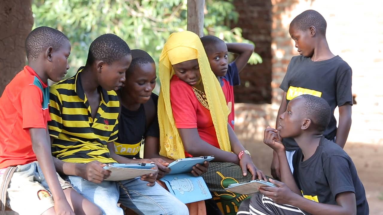 Photo of children fathering to learn from tablets